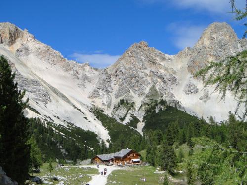a snow covered mountain with a house in front of it at Garni Irsara in San Cassiano