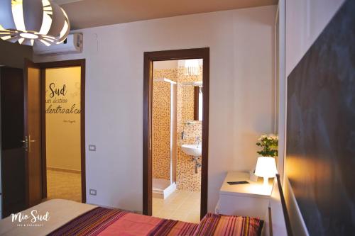 ein Schlafzimmer mit einem Bett und ein Badezimmer mit einem Waschbecken in der Unterkunft Mio Sud in Cosenza