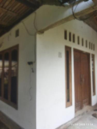 un edificio blanco con puerta y ventanas en Kasutapan homestay, en Kembangarum