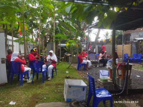 un grupo de personas sentadas en sillas bajo una tienda en Kasutapan homestay, en Kembangarum
