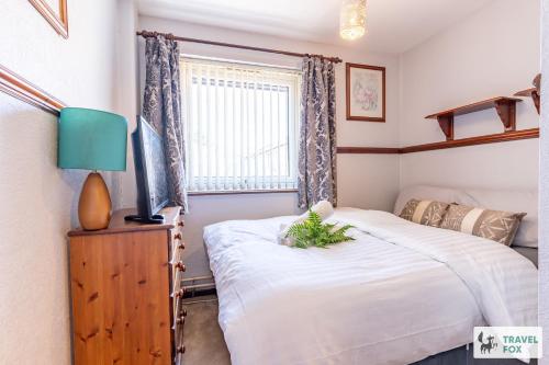 a bedroom with two beds and a tv and a window at Central Aster House, 3 Bedrooms, Parking in Nottingham