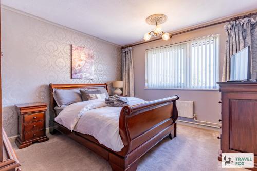 a bedroom with a bed and a dresser and a window at Central Aster House, 3 Bedrooms, Parking in Nottingham