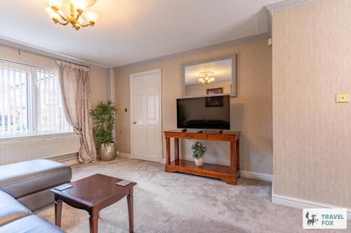 a living room with a couch and a flat screen tv at Central Aster House, 3 Bedrooms, Parking in Nottingham