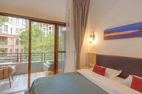 a hotel room with a bed and a balcony at Heinemann Hotel loft suite with two king beds B306 with a jacuzzi and a local in Baoguosi