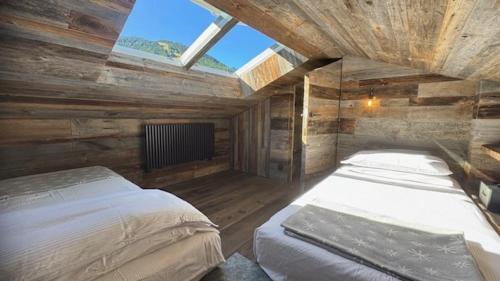 a bedroom with two beds in a wooden room at TERRY LODGE-Luxury Apartment-central ski area in Aprica