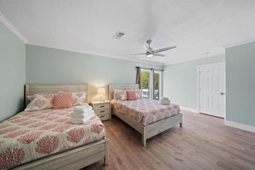 Un dormitorio con dos camas y un ventilador de techo. en Cozy home close to Kemah Boardwalk with game room, en Clear Lake Shores