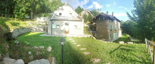 an old stone house on a grassy hill at Il Borgo Dei Celti in Fiumalbo