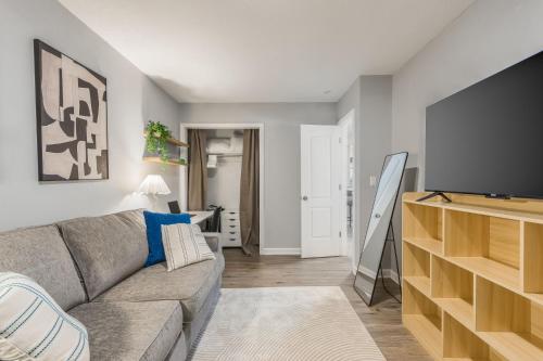 a living room with a couch and a flat screen tv at Home in Kansas City 15 mins to KCI with a KING bed and workspace in Riverside