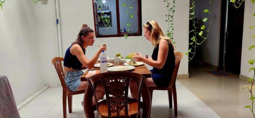 two women sitting at a table eating food at Tiny Villa Homestay - Only For Foreign Bookings in Kurunegala
