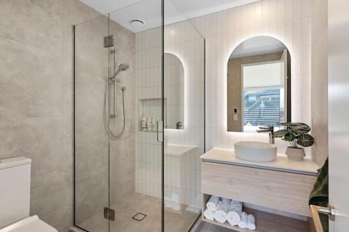 a bathroom with a glass shower and a sink at Stay in the Heart of the City 3 Bed 3 Bath in Christchurch