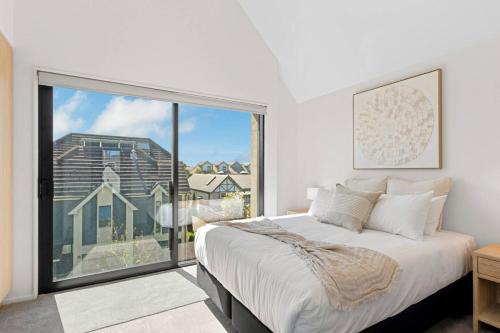 a bedroom with a large white bed and a large window at Stay in the Heart of the City 3 Bed 3 Bath in Christchurch