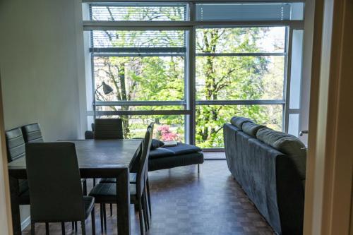 a dining room with a table and chairs and a large window at Giardini Rooms in Cremona