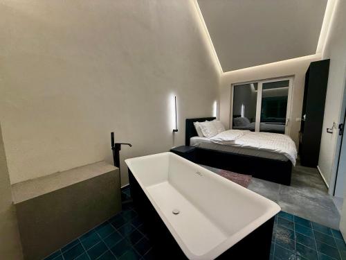 a bathroom with a bath tub and a bed at Brezovica Lux in Brezovicë