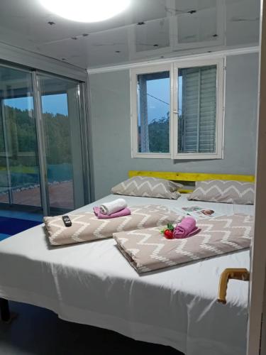 two beds in a room with towels on them at Gyps Vikendica with Swimming Pool and Sauna in Tuzla