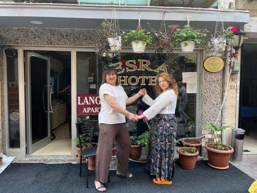 two women shaking hands in front of a store at Langa Esra in Istanbul