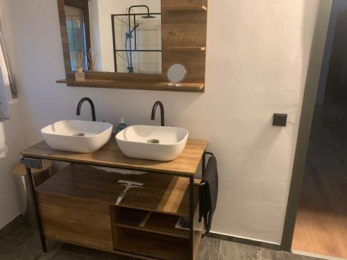 SosbergにあるFerienwohnung Schimpfのバスルーム(木製カウンターのシンク2つ付)