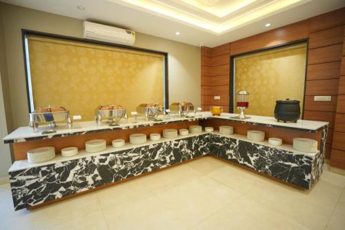 um restaurante com um balcão com pratos em Samraddh Palace em Alwar