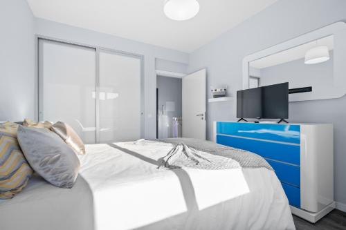 a bedroom with a bed with a blue dresser and a tv at Mimi Holiday House - Free Parking in Funchal