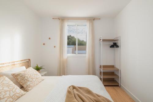 a white bedroom with a bed and a window at Mirador de la Peña in Arcos de la Frontera