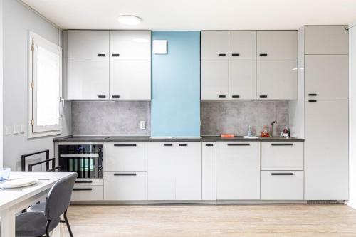 a kitchen with white cabinets and a table at GuestReady - Cosy and sunny studio in Antony in Antony