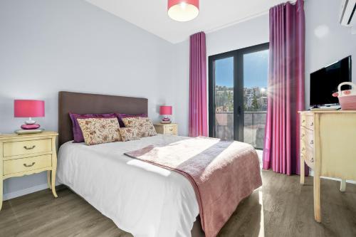 a bedroom with a bed and a window with pink curtains at Mimi Holiday House - Free Parking in Funchal