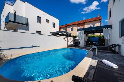 a swimming pool in front of a building at Villa Essenza Mare in Vodice with private pool & pet friendly - only 650 meters from the beach in Vodice