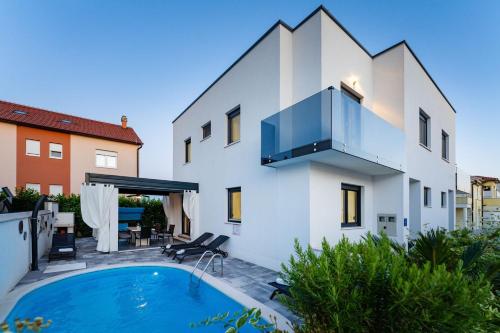 a villa with a swimming pool and a house at Villa Essenza Mare in Vodice with private pool & pet friendly - only 650 meters from the beach in Vodice