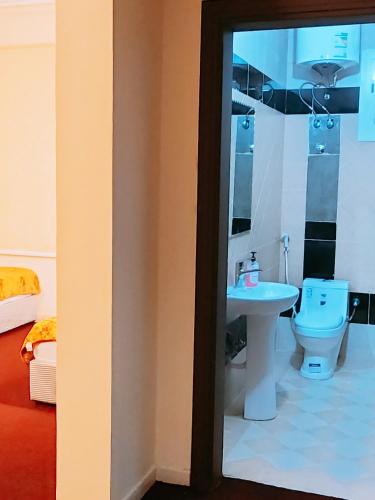 a bathroom with a toilet and a sink at نزل الزائر 2 in Medina