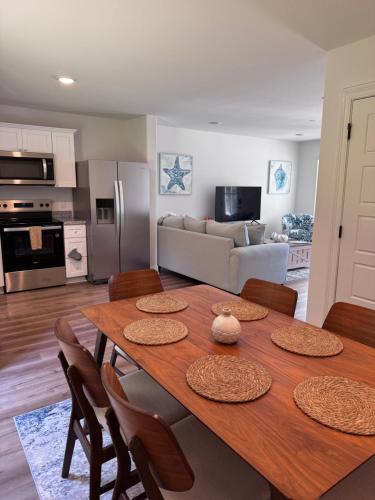 a kitchen and dining room with a wooden table with chairs at Chic Beach Home Near Airport Casino Base in Gulfport