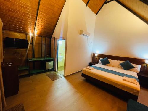 a bedroom with a bed and a bathroom with a shower at Citrine Belihuloya in Belihul Oya