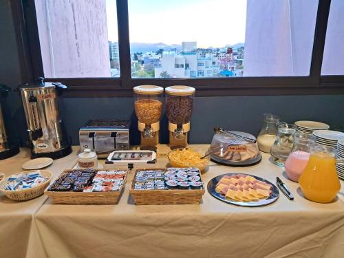 a table with many different types of food on it at Central Suites Hotel in Villa Carlos Paz
