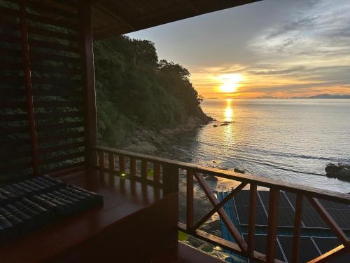 a sunset from the balcony of a house at Mama's Bungalows Koh Chang Ranong in Koh Chang Ranong