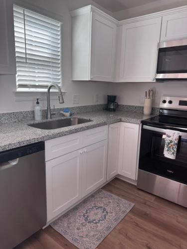 a kitchen with white cabinets and a sink at Chic Beach Home Near Airport Casino Coliseum Base in Gulfport