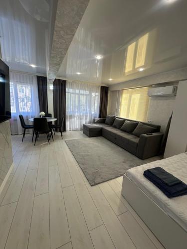 ein Wohnzimmer mit Sofa und Tisch in der Unterkunft Квартира 1,5 Евро-люкс in Öskemen