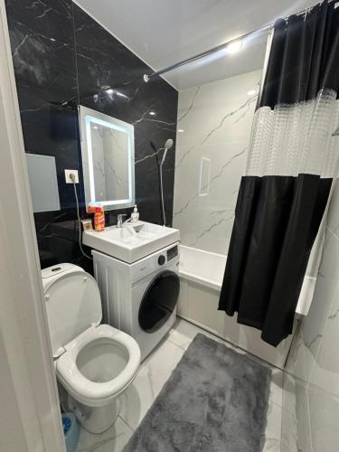 ein Badezimmer mit Toilette, Waschbecken und Dusche in der Unterkunft Квартира 1,5 Евро-люкс in Öskemen
