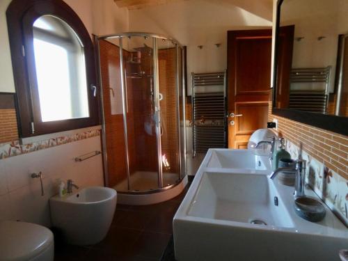 a bathroom with a sink and a shower and a toilet at Villa Baia Verde in Marina di Modica