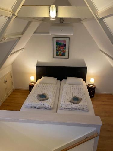 a bedroom with two white beds in a attic at BenBZuiderzee in Hattem