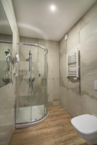 a bathroom with a shower and a toilet at Akacja Medical Resort in Ciechocinek