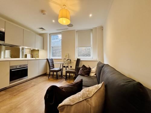 ein Wohnzimmer mit Sofa und Tisch in der Unterkunft Charming 1BR City Retreat soho&covent garden in London
