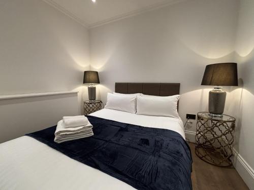 ein Schlafzimmer mit einem weißen Bett und zwei Lampen in der Unterkunft Charming 1BR City Retreat soho&covent garden in London