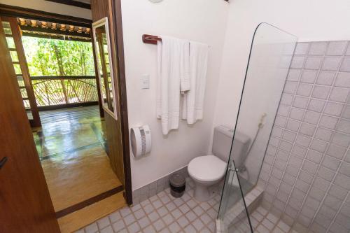 a bathroom with a toilet and a shower with towels at Vilangelim Eco-Pousada in Imbassai