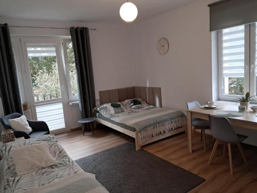 Un dormitorio con una cama y una mesa y sillas. en Apartament VERDE Malbork centrum, en Malbork