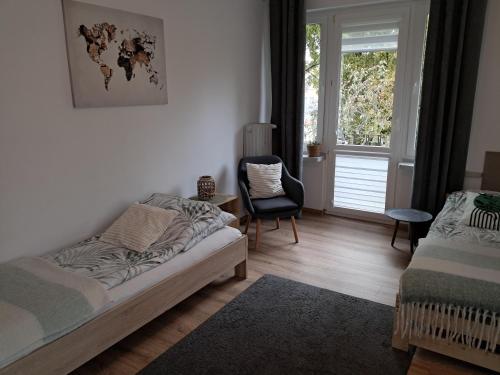 Un dormitorio con una cama y una silla y una ventana. en Apartament VERDE Malbork centrum, en Malbork
