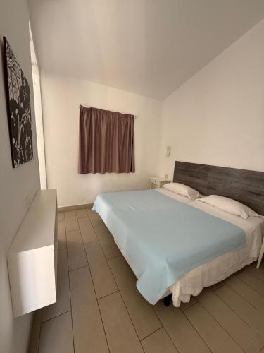 a bedroom with a large white bed and a window at Secret Bungalow, Los Arcos in San Bartolomé