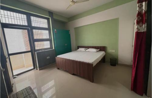 ein Schlafzimmer mit einem Bett und einem großen Fenster in der Unterkunft Awaraj Home Stay in Agra