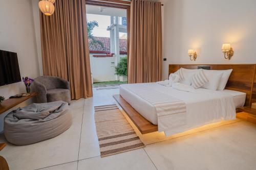 a bedroom with a large bed and a living room at Madiha Venus in Matara