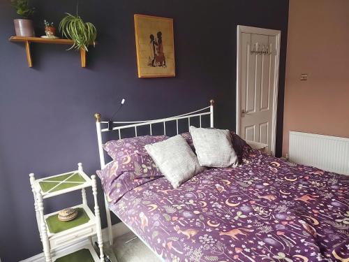 a bedroom with a bed with a purple comforter at Bishop bed and breakfast in Bishop Auckland