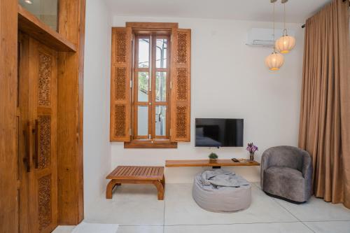 a living room with a chair a table and a tv at Madiha Venus in Matara
