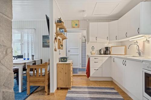 a kitchen with white cabinets and a dining room at Cabin in Lofoten - Northern Lights view 