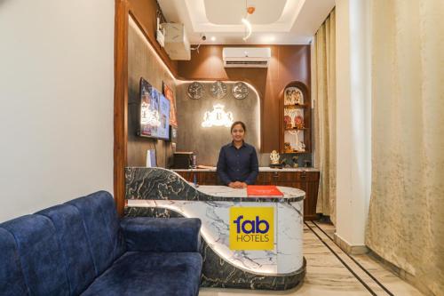 a woman standing behind a counter in a room at FabHotel Raj Palace in Lucknow